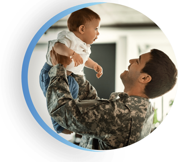 A military man holding a baby up high